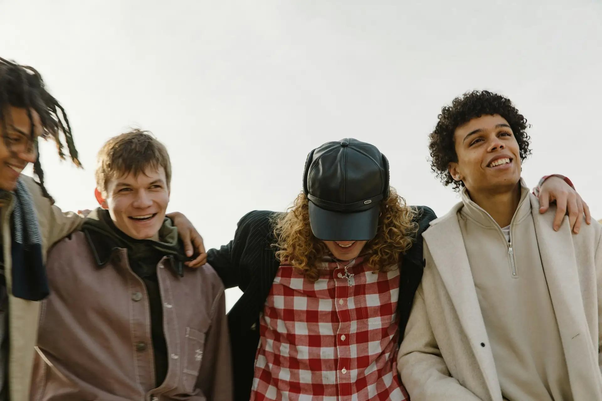 Group of friends smiling and laughing together outside.