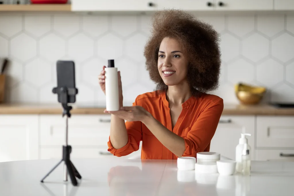 Woman demonstrating skincare product on camera.