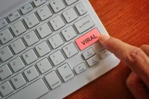 Finger pressing keyboard label VIRAL.