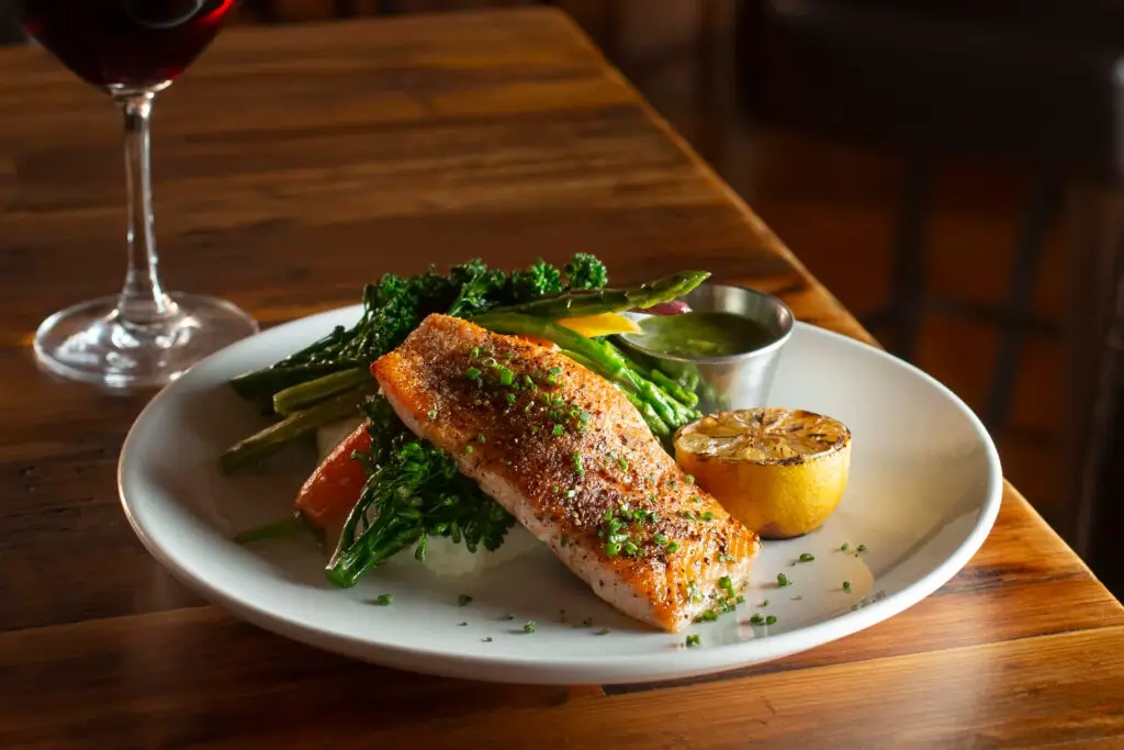 Grilled salmon with vegetables and lemon on plate