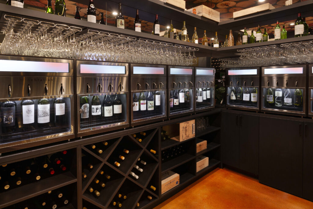 Modern wine dispenser with bottles and glasses.