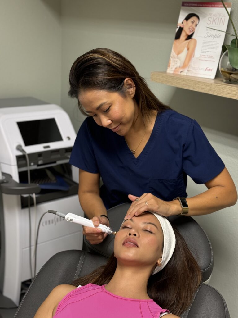 Esthetician performing facial treatment in salon chair.
