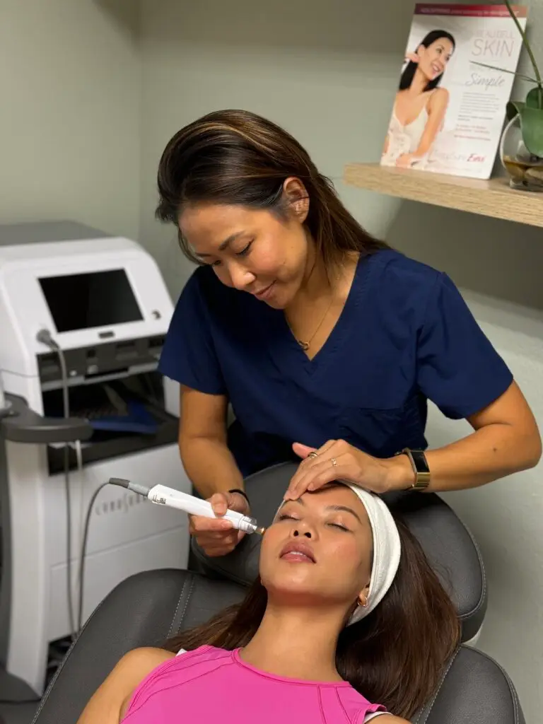 Esthetician performing facial treatment in salon chair.