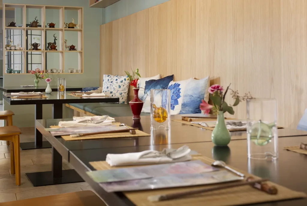 Cozy restaurant with wooden tables and colorful cushions.