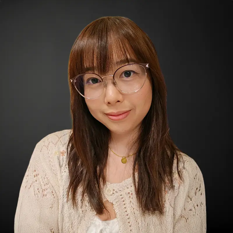 Smiling person with glasses and brown hair.