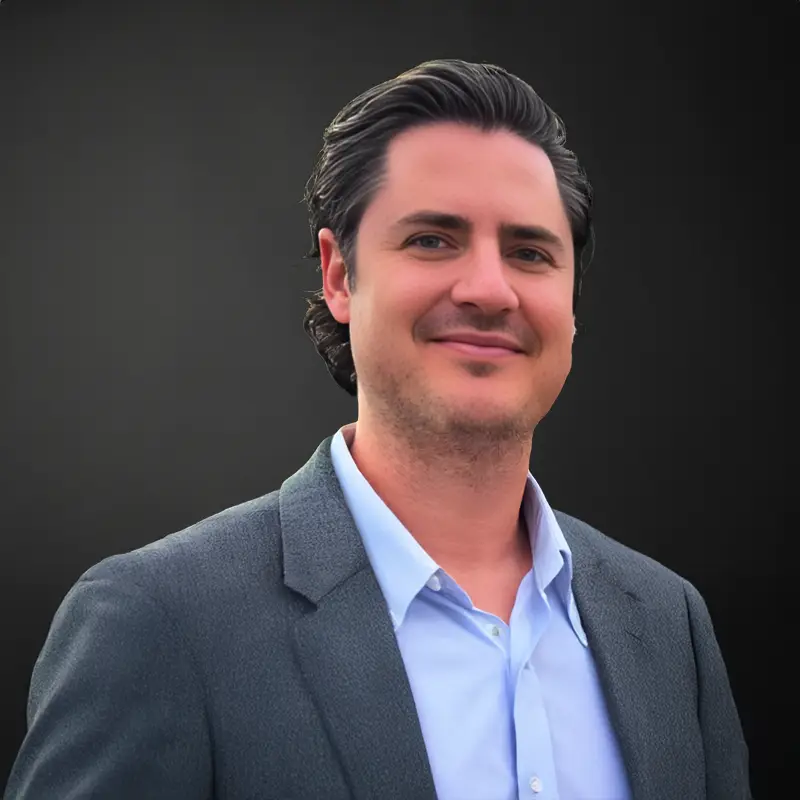 Smiling person in a suit jacket.