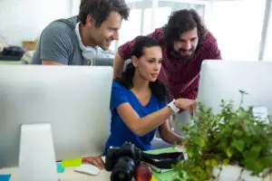 Team collaborating on computer project in office