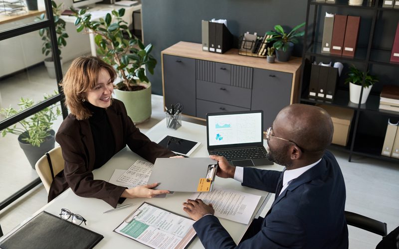 businesswoman giving financial documents to businessman