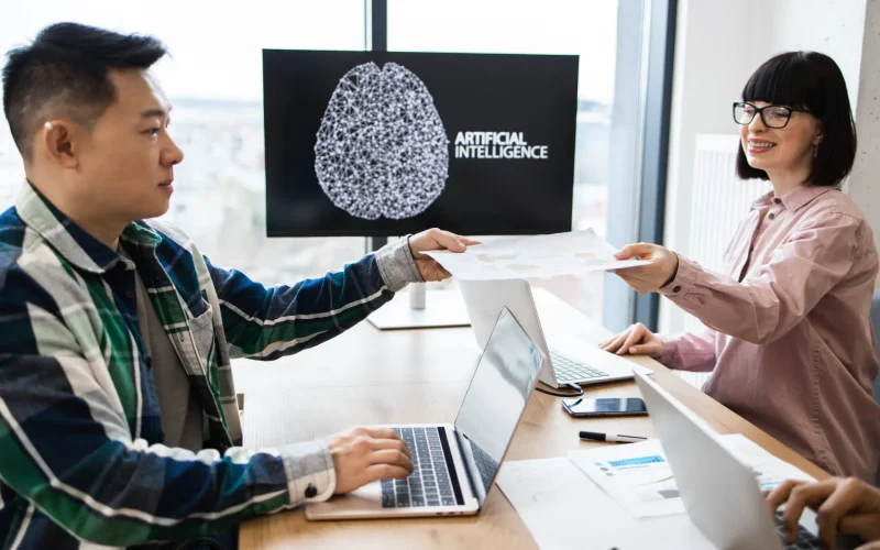 Colleagues discussing artificial intelligence project in office.