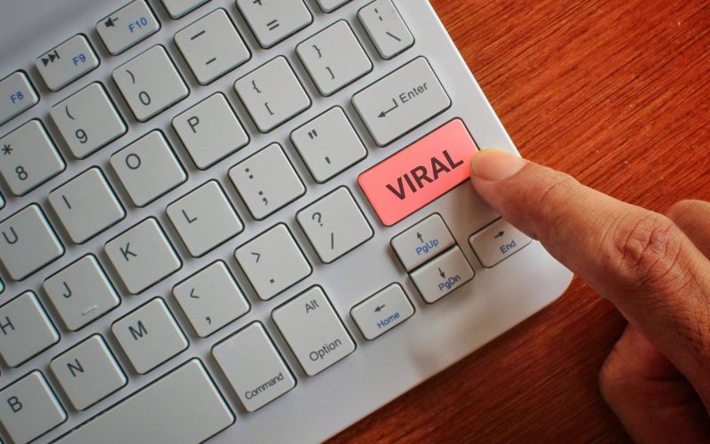 Finger pressing keyboard label VIRAL.