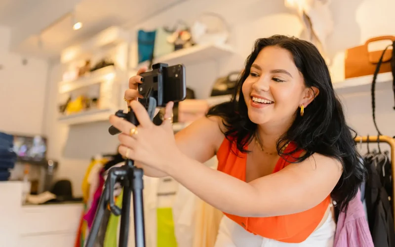 Woman filming with smartphone on tripod in store