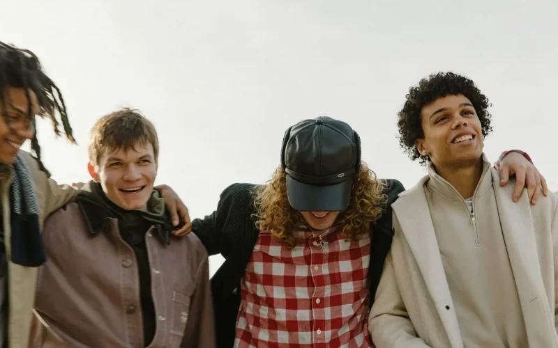 Group of friends smiling and laughing together outside.