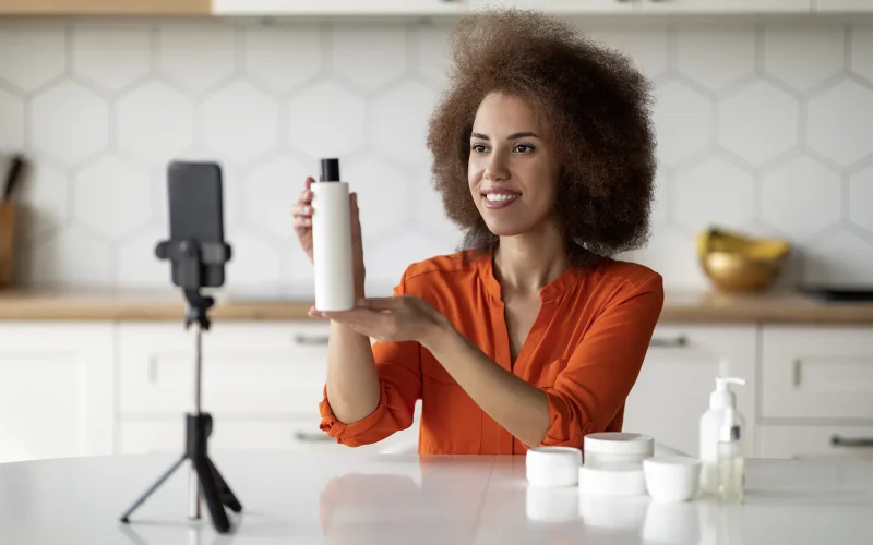 Woman demonstrating skincare product on camera.