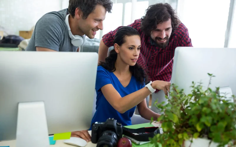 Team collaborating on computer project in office